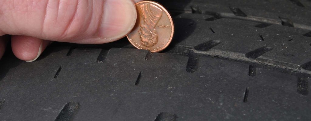 Gros plan sur la vérification de la pression des pneus et de la profondeur de la bande de roulement