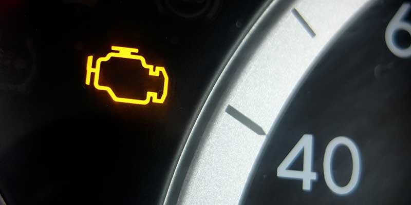 Gros plan sur le voyant d'alerte moteur du tableau de bord