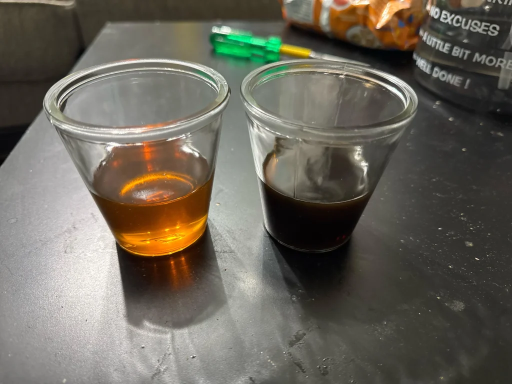 Comparaison côte à côte de l'huile d'ambre fraîche et de l'huile noire ancienne. Huile neuve (à gauche) vs. huile à changer (à droite)