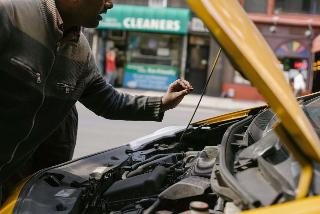 Inspection du compartiment moteur d'une voiture d'occasion à Douala